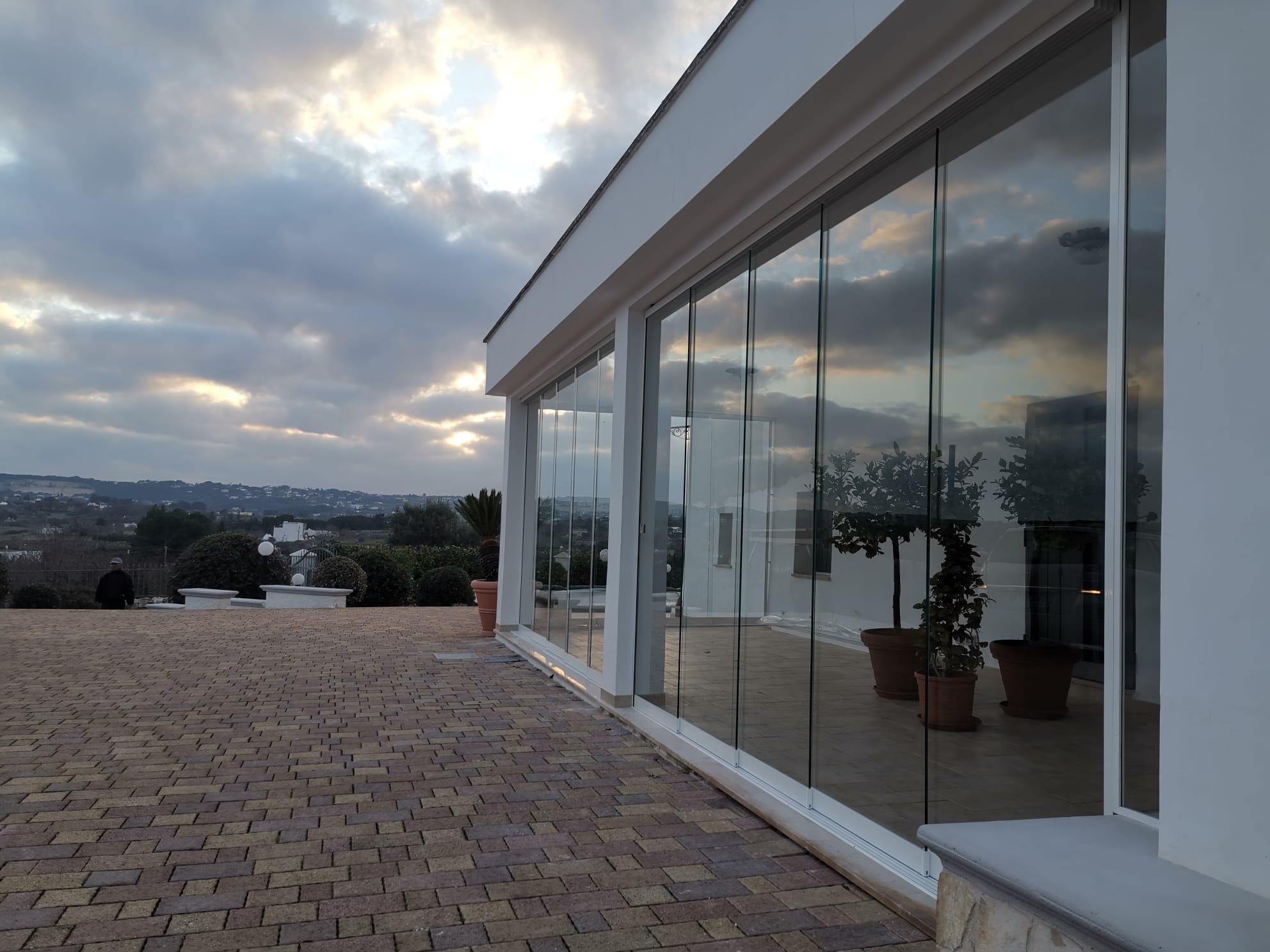 Edificio moderno con vetrate riflettenti, cielo nuvoloso.
